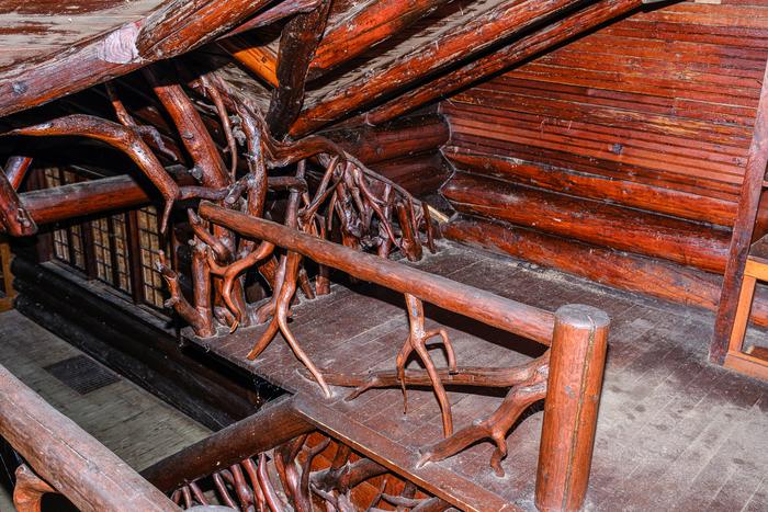 A loft railing made of tree roots at the stairwell