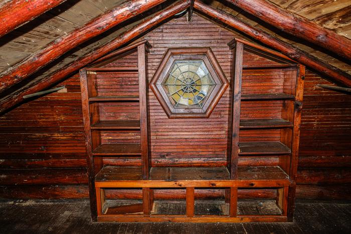 A hexagonal window in the loft gable with built-in shelves and a bench