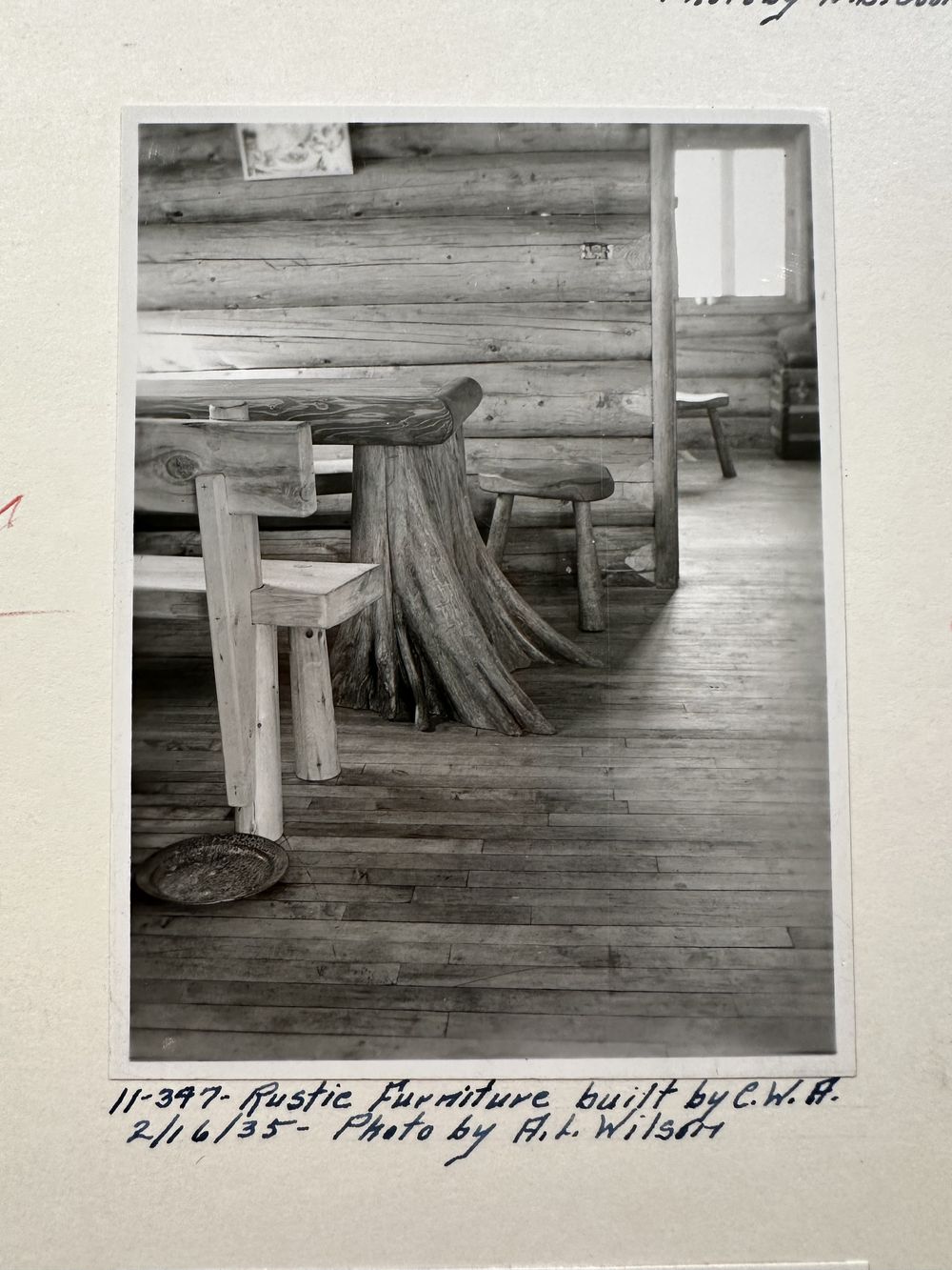 A rustic table and benches built from logs and stumps inside the cabin